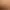 Junge Frau liegt mit offenen Augen und einer Hand auf ihrem Gesicht