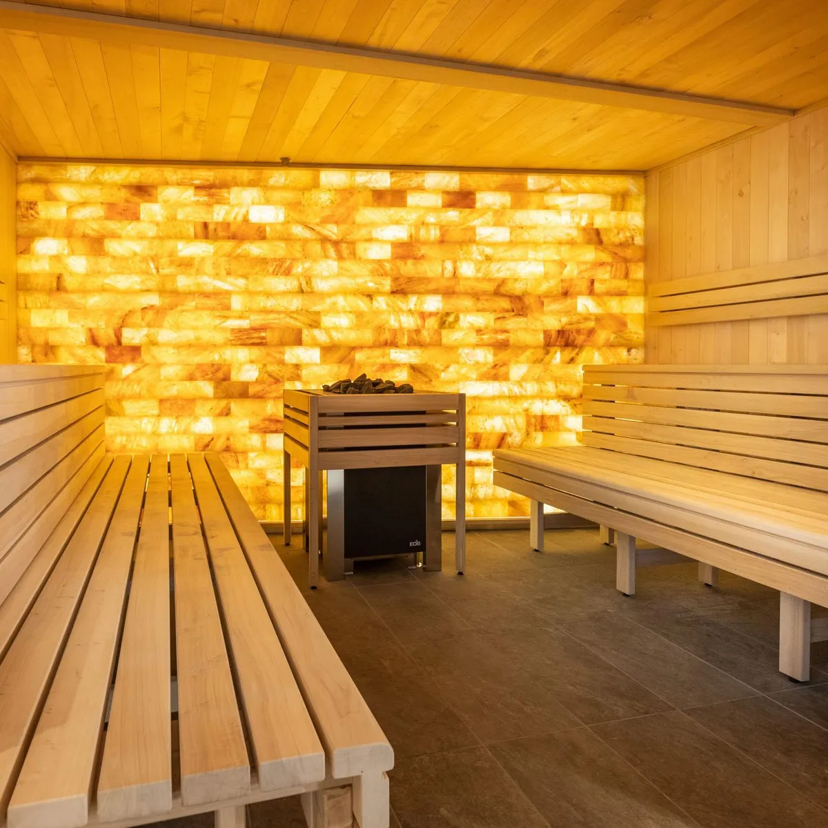 Holzraum mit Bänken und einer von Lichtmustern beleuchteten Wand