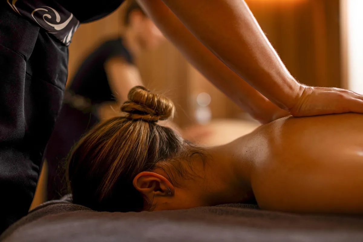 Eine Person, die auf dem Bauch liegt, erhält in einem professionellen Rahmen eine Massage.