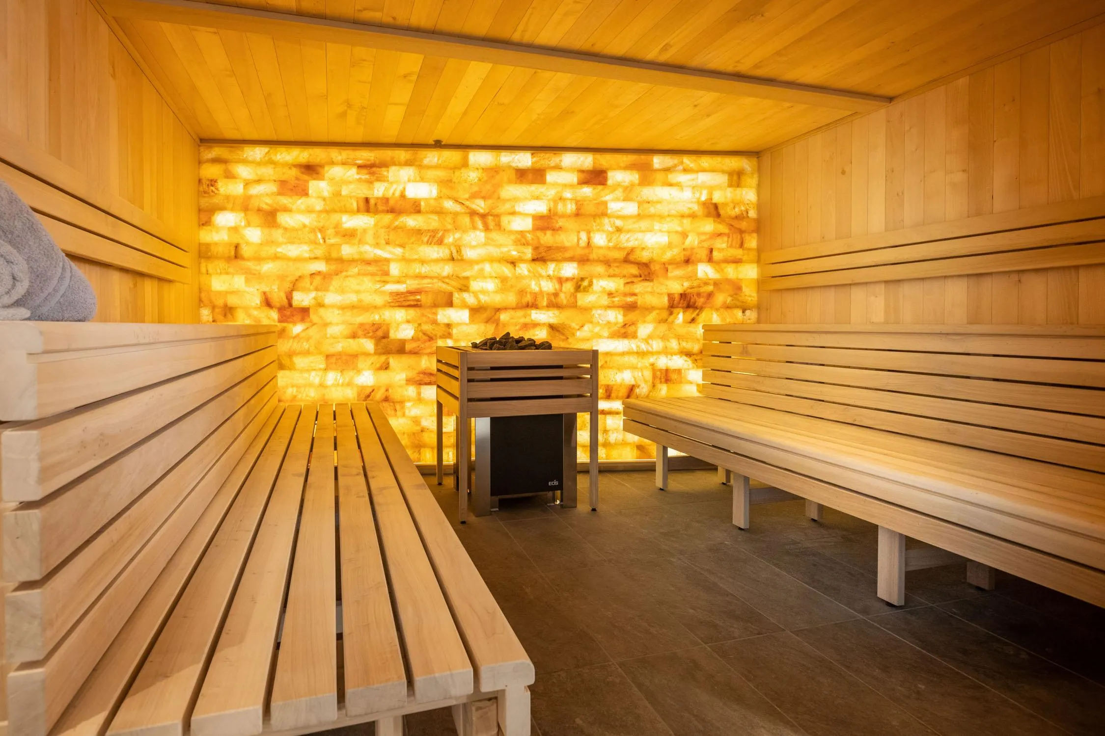 Holzraum mit Bänken und einer von Lichtmustern beleuchteten Wand